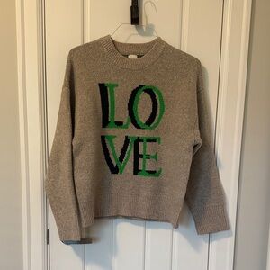 a new day Tan Sweater with Green and Black Lettering